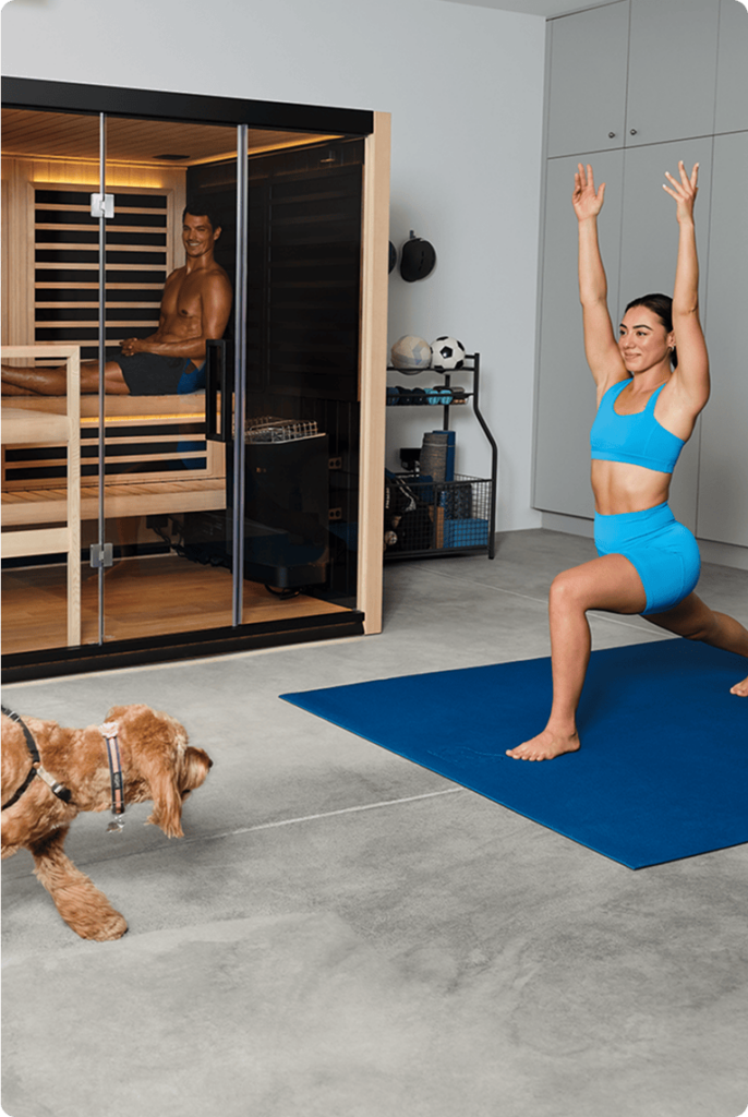One person relaxing in a sauna and another stretching on a mat outside