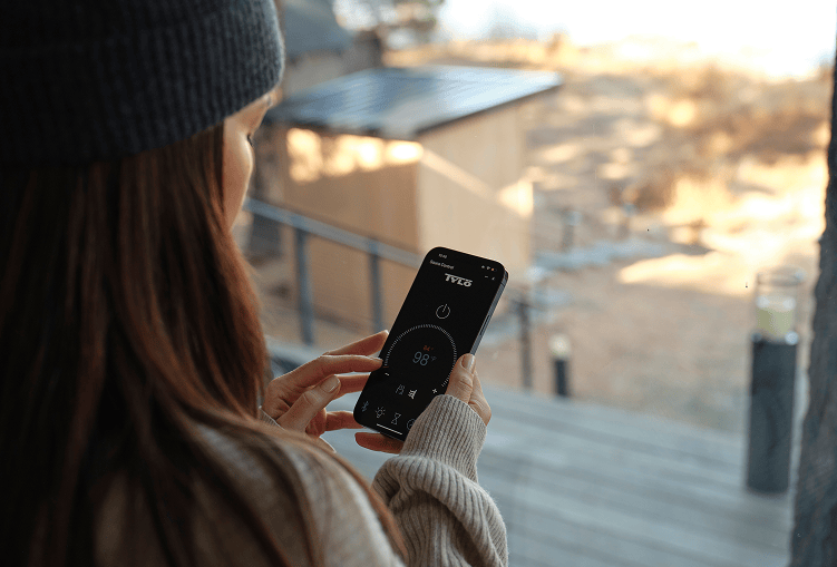 A person looking at their phone with the Tylo lifestyle app open