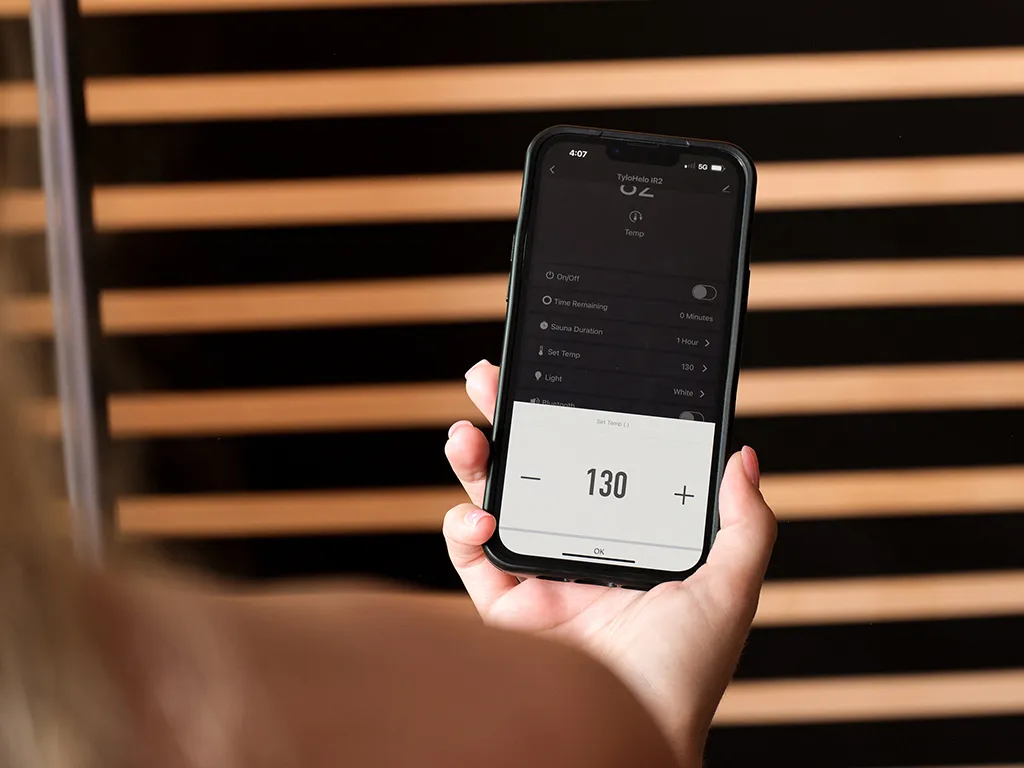 A person looking at their phone with the Tylo lifestyle app open