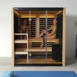 A zoomed out view of two people sitting inside of a Tylo Kiruna Hybrid sauna, relaxing and laughing