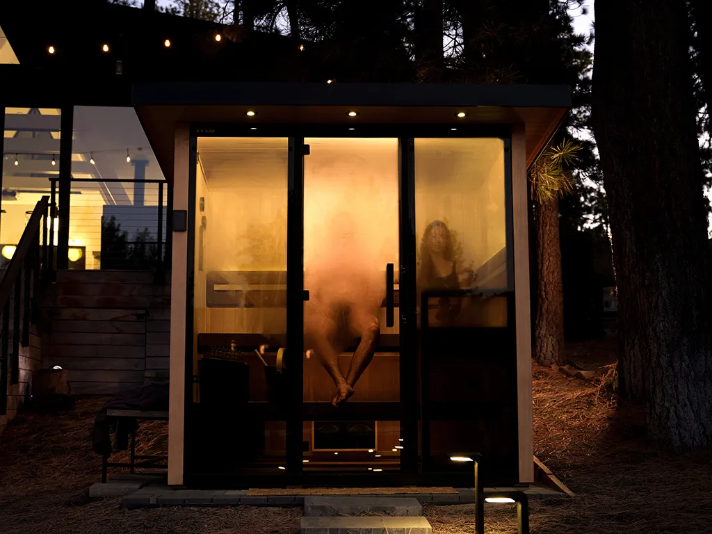 Two people sitting in a Tylo Lulea sauna at night